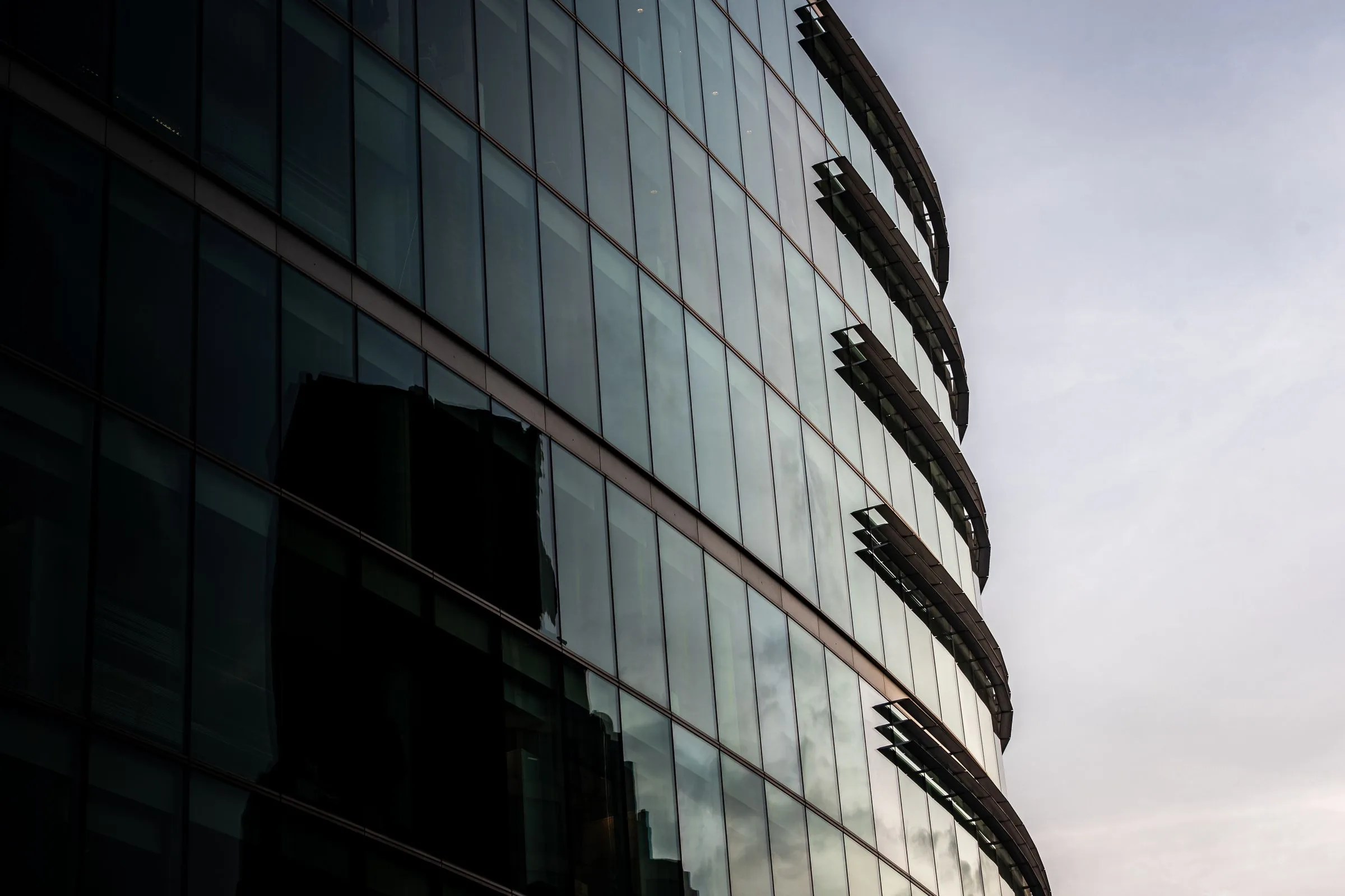 Modern glass-fronted commercial office building reflecting the sky